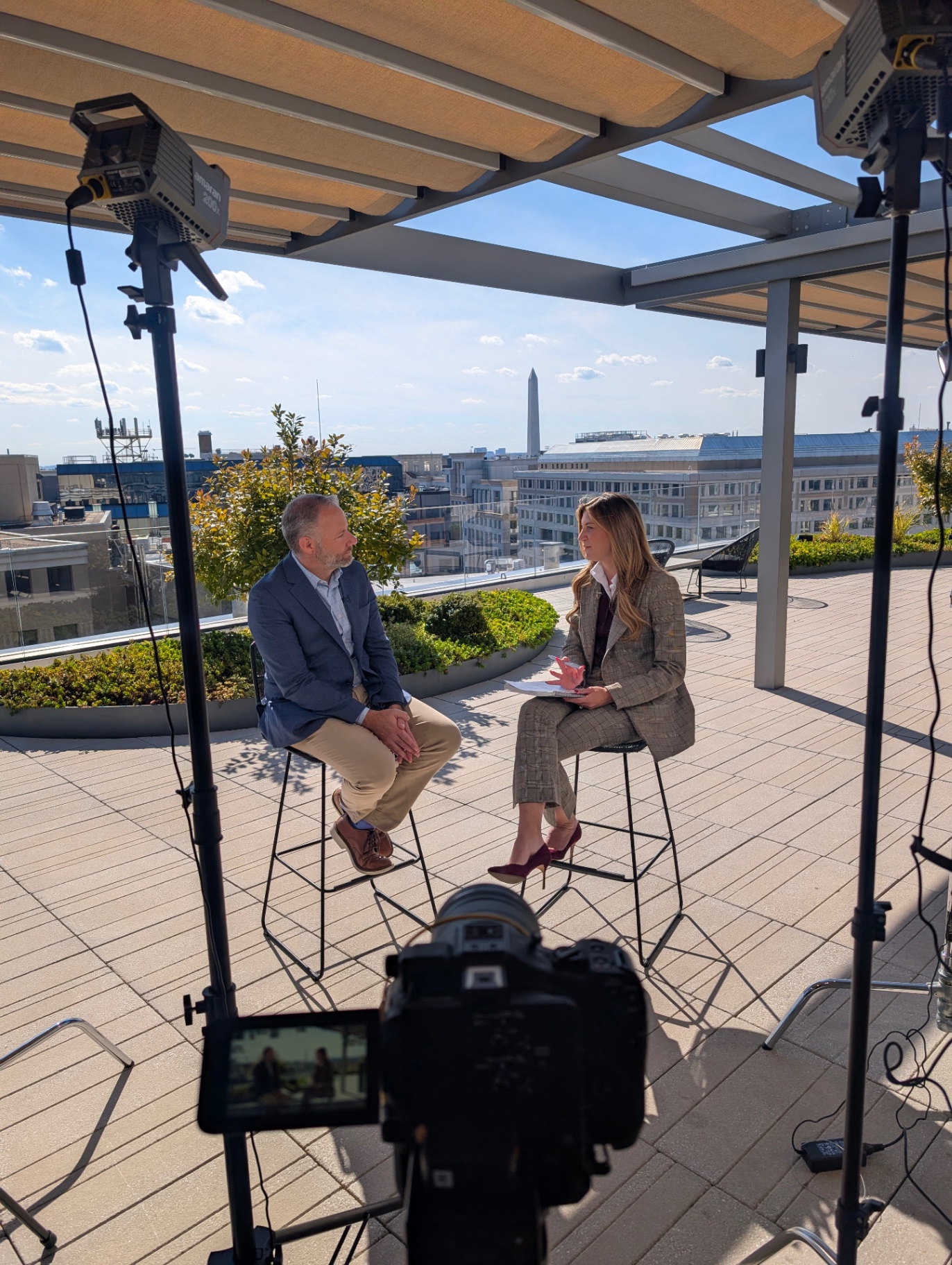 Sadie St Lawrence interviewing a guest on a Washington DC rooftop